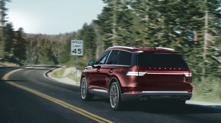 A 2024 Lincoln Aviator® SUV is being driven on a winding mountain road | Vista Lincoln Woodland Hills in Woodland Hills CA