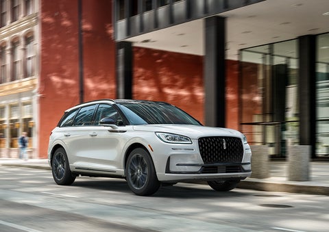The 2024 Lincoln Corsair® SUV with the Jet Appearance Package and a Pristine White exterior is parked on a city street. | Vista Lincoln Woodland Hills in Woodland Hills CA