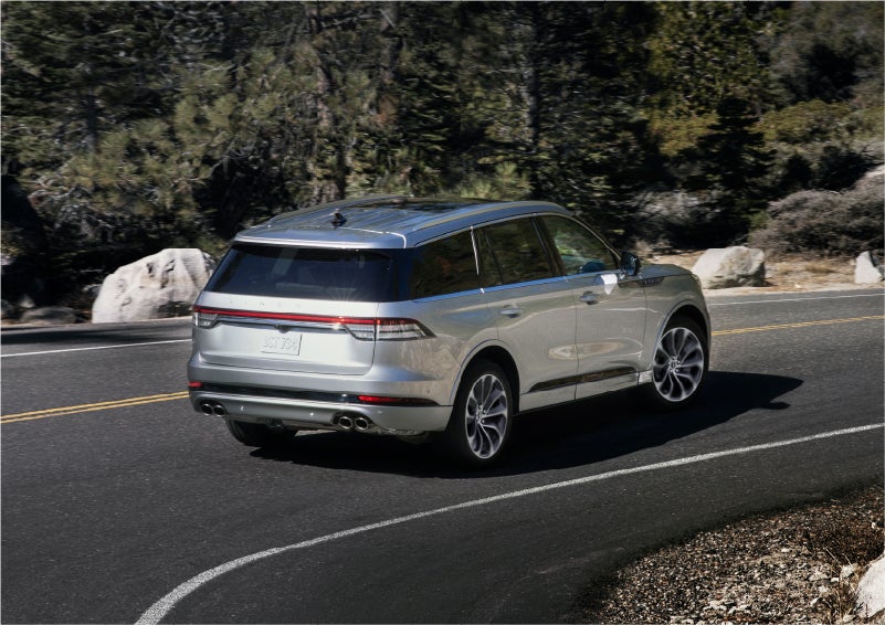 A 2023 Lincoln Aviator® Grand Touring model is shown being driven on a tight turn of a mountain road | Vista Lincoln Woodland Hills in Woodland Hills CA