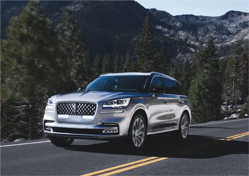 A 2023 Lincoln Aviator® Grand Touring SUV being driven on a winding road to demonstrate the capabilities of all-wheel drive | Vista Lincoln Woodland Hills in Woodland Hills CA