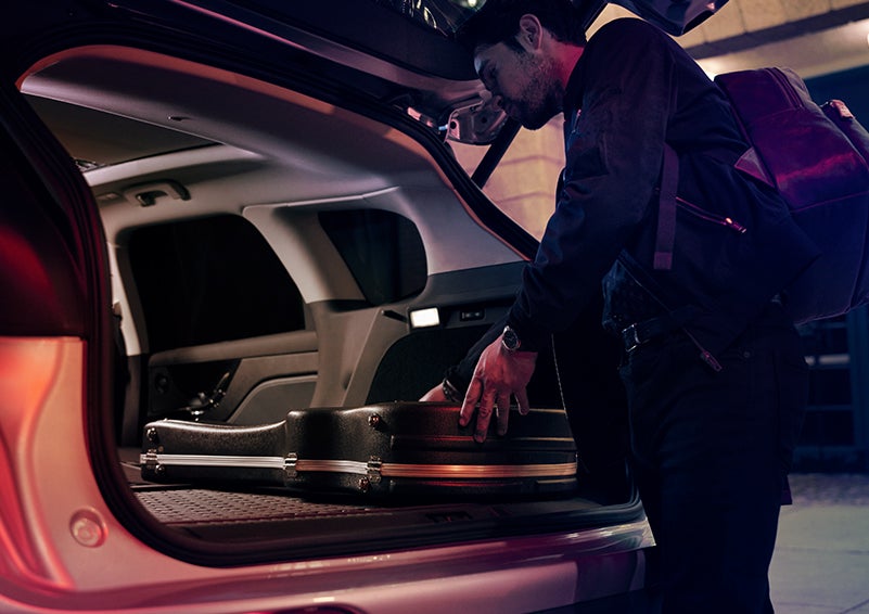 A man is shown loading cargo into the rear of a 2024 Lincoln Corsair® SUV with the second-row seats folded flat. | Vista Lincoln Woodland Hills in Woodland Hills CA