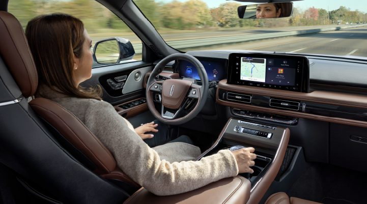 A woman is seen sitting in the driver’s seat of her 2025 Lincoln Aviator® SUV with her hands off the steering wheel. | Vista Lincoln Woodland Hills in Woodland Hills CA