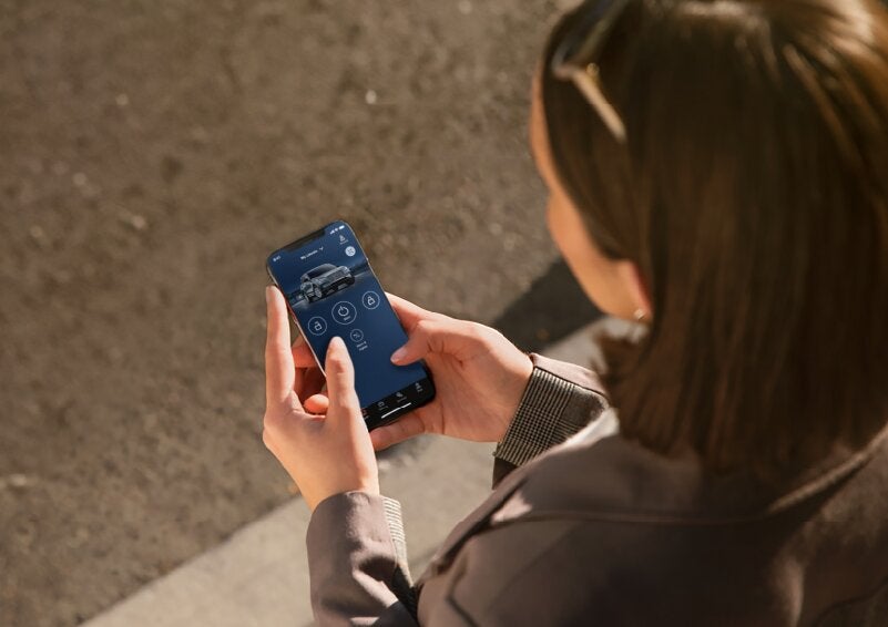 A person is shown interacting with a smartphone to connect to a Lincoln vehicle via the Lincoln Way® App. | Vista Lincoln Woodland Hills in Woodland Hills CA