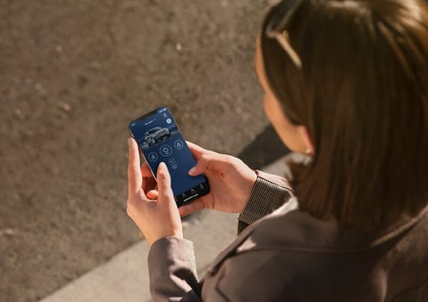 A person is shown interacting with a smartphone to connect to a Lincoln vehicle via the Lincoln Way® App. | Vista Lincoln Woodland Hills in Woodland Hills CA