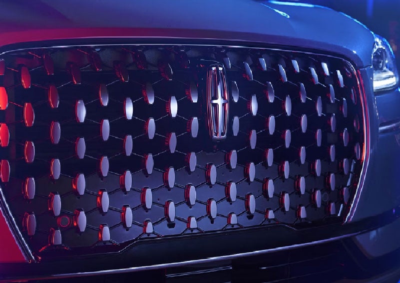 The grille of a 2025 Lincoln Corsair® SUV reflects neon light at night. | Vista Lincoln Woodland Hills in Woodland Hills CA