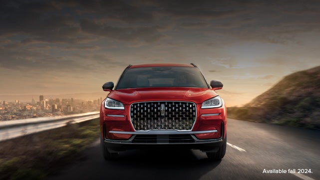 A 2025 red Lincoln Corsair® SUV is being driven down a road at sunset. | Vista Lincoln Woodland Hills in Woodland Hills CA