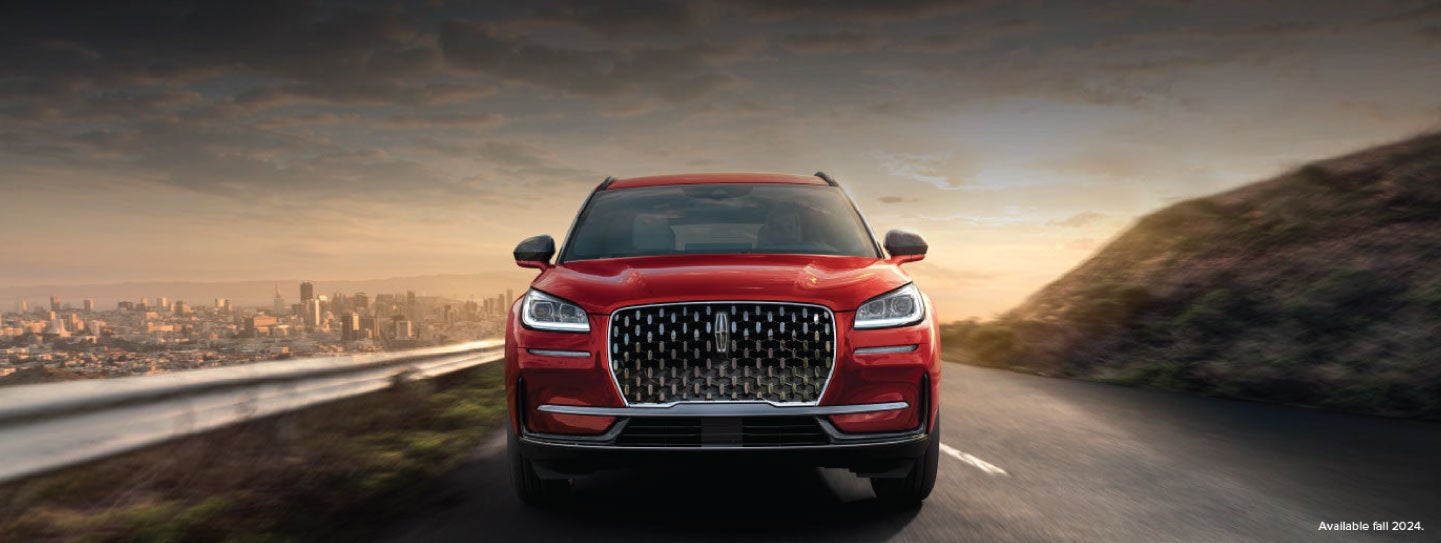 A 2025 red Lincoln Corsair® SUV is being driven down a road at sunset. | Vista Lincoln Woodland Hills in Woodland Hills CA