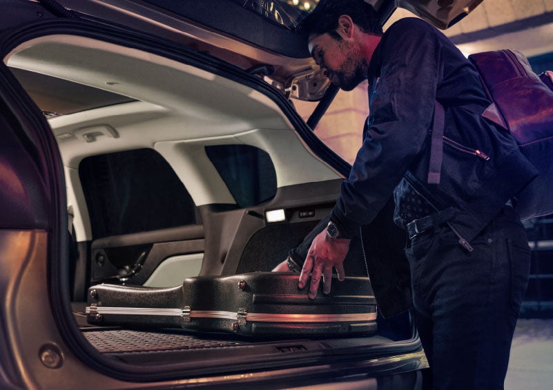 A man is shown loading cargo into the rear of a 2024 Lincoln Corsair® SUV with the second-row seats folded flat. | Vista Lincoln Woodland Hills in Woodland Hills CA